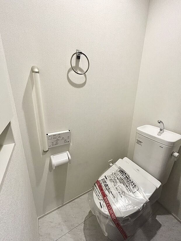 ウォシュレット機能付きのトイレ。収納もあり実用性も兼ね備えた造り。 