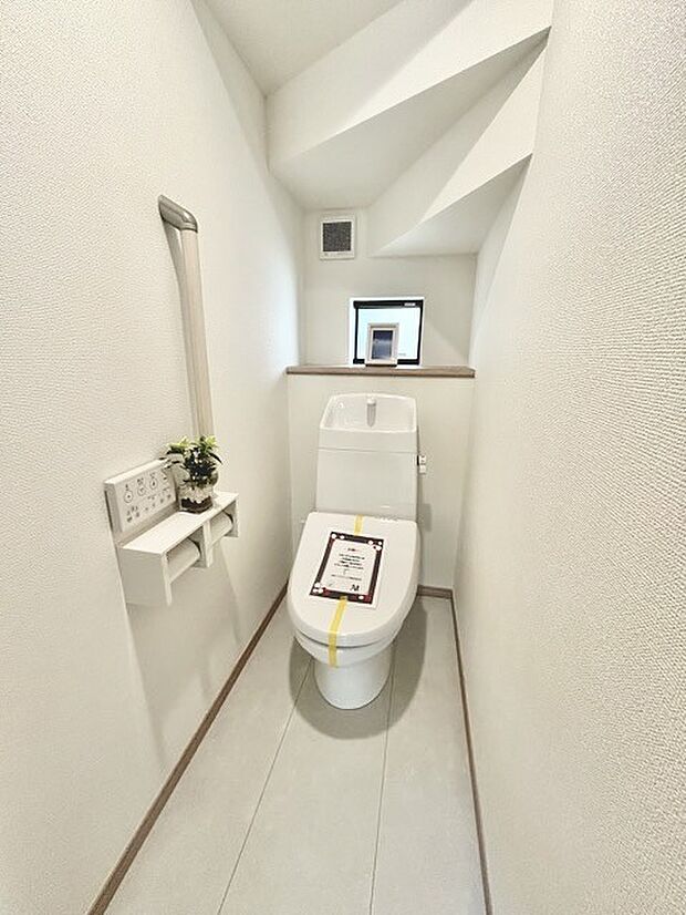 ウォシュレット機能付きのトイレ。収納もあり実用性も兼ね備えた造り。