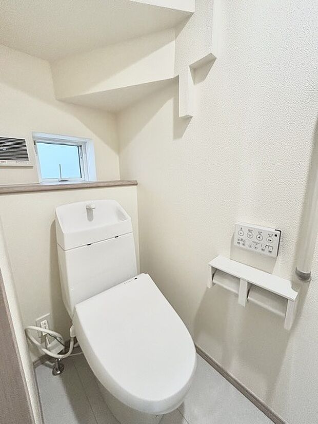 ウォシュレット機能付きのトイレ。換気のしやすい窓付きで、収納もあり実用性も兼ね備えた造り。