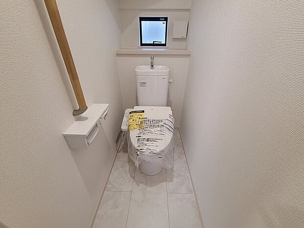 ウォシュレット機能付きのトイレ。換気のしやすい窓付きで、収納もあり実用性も兼ね備えた造り。