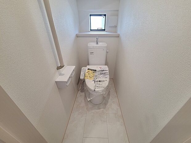 ウォシュレット機能付きのトイレ。換気のしやすい窓付きで、収納もあり実用性も兼ね備えた造り。