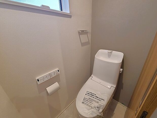 ウォシュレット機能付きのトイレ。換気のしやすい窓付きで、収納もあり実用性も兼ね備えた造り。 