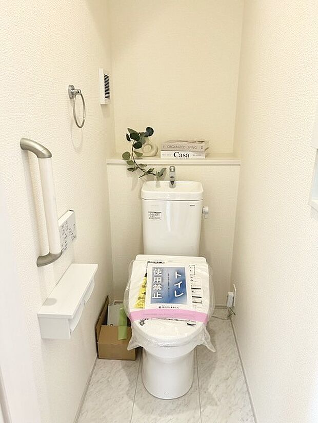 ウォシュレット機能付きのトイレ。収納もあり実用性も兼ね備えた造り。 