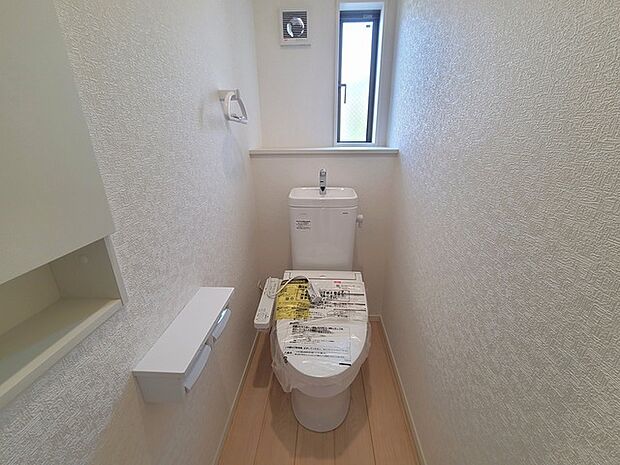 ウォシュレット機能付きのトイレ。換気のしやすい窓付きで、収納もあり実用性も兼ね備えた造り。
