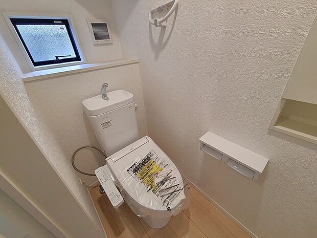 ウォシュレット機能付きのトイレ。換気のしやすい窓付きで、収納もあり実用性も兼ね備えた造り。