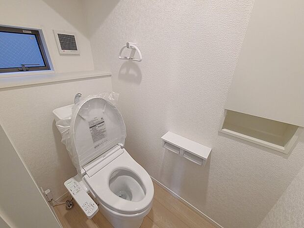 ウォシュレット機能付きのトイレ。換気のしやすい窓付きで、収納もあり実用性も兼ね備えた造り。