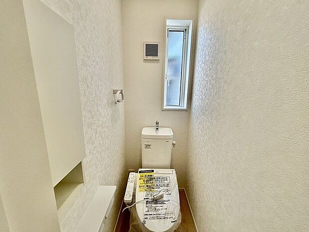 ウォシュレット機能付きのトイレ。換気のしやすい窓付きで、収納もあり実用性も兼ね備えた造り。