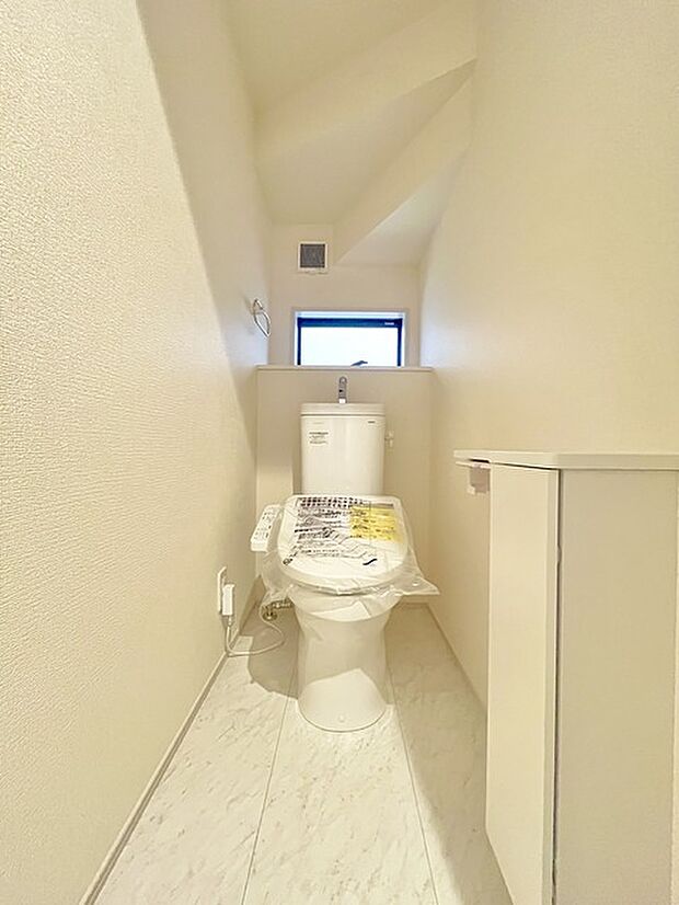 ウォシュレット機能付きのトイレ。換気のしやすい窓付きで、収納もあり実用性も兼ね備えた造り。