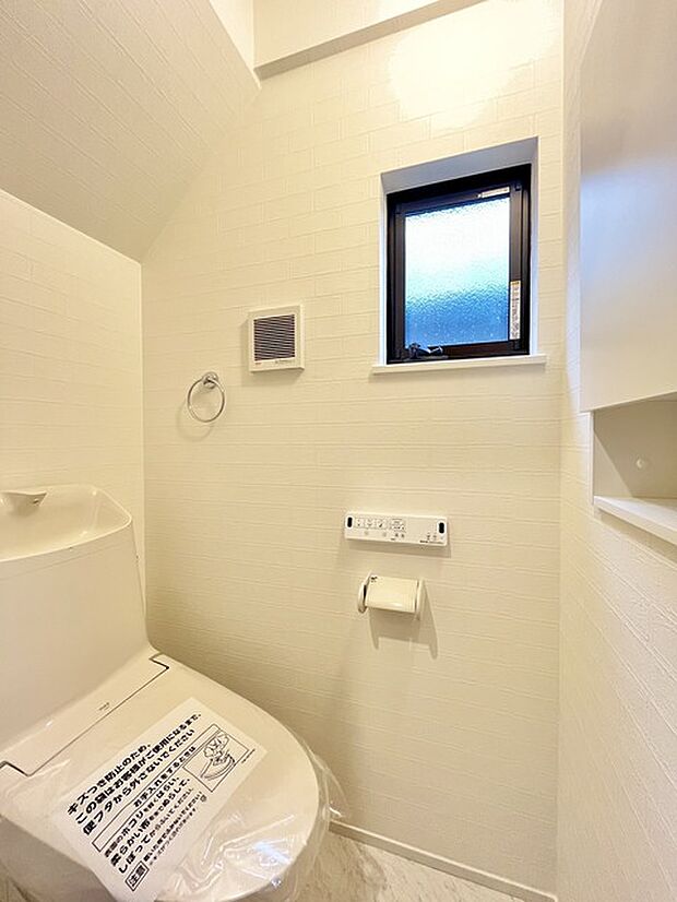 ウォシュレット機能付きのトイレ。換気のしやすい窓付きで、収納もあり実用性も兼ね備えた造り。