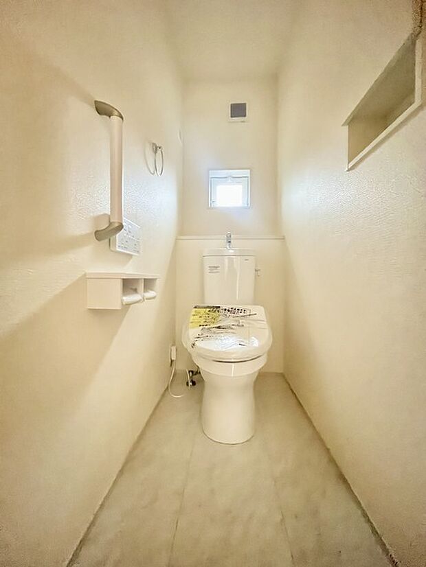 ウォシュレット機能付きのトイレ。換気のしやすい窓付きで、収納もあり実用性も兼ね備えた造り。