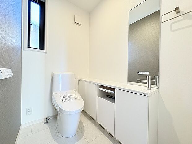 ウォシュレット機能付きのトイレ。収納もあり実用性も兼ね備えた造り。 