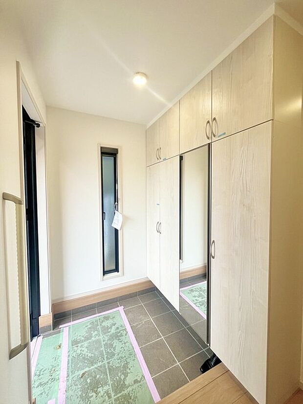 お宅の顔となる明るく開放的な玄関。ご家族皆様様の靴を収納できるスペースと全身鏡があり、お出掛け前に身だしなみチェックもできます。 