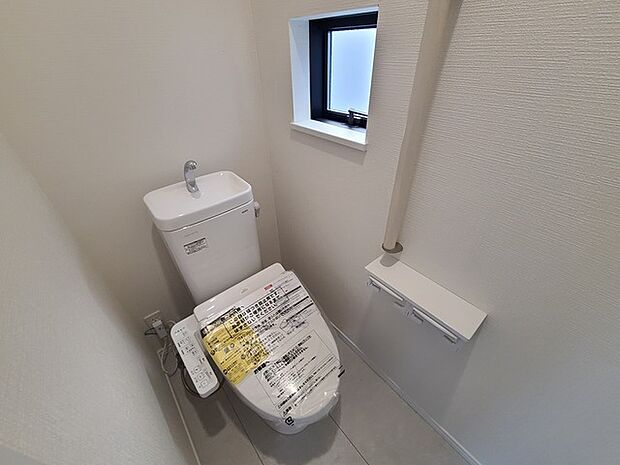 ウォシュレット機能付きのトイレ。換気のしやすい窓付きで、収納もあり実用性も兼ね備えた造り。