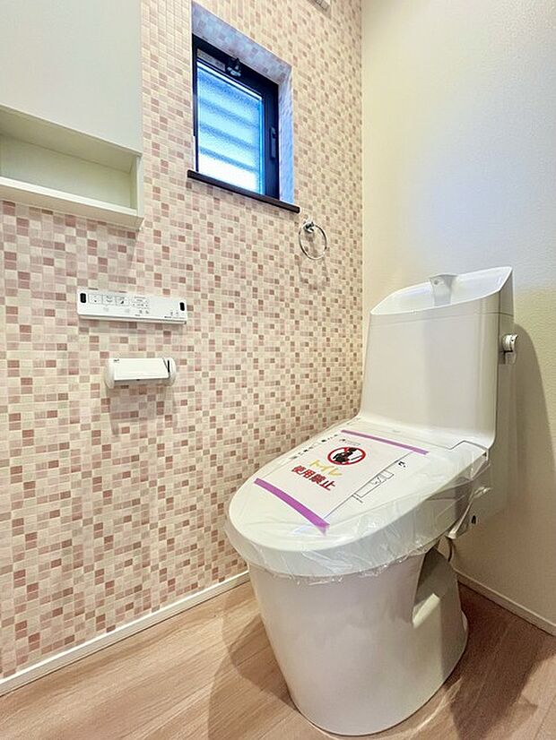 ウォシュレット機能付きのトイレ。換気のしやすい窓付きで、収納もあり実用性も兼ね備えた造り。