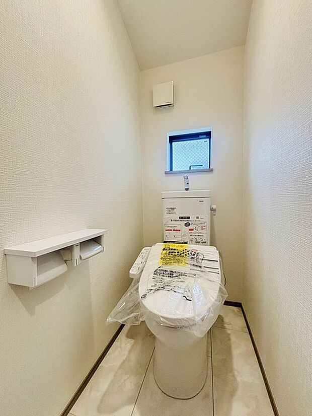 ウォシュレット機能付きのトイレ。換気のしやすい窓付きで、収納もあり実用性も兼ね備えた造り。