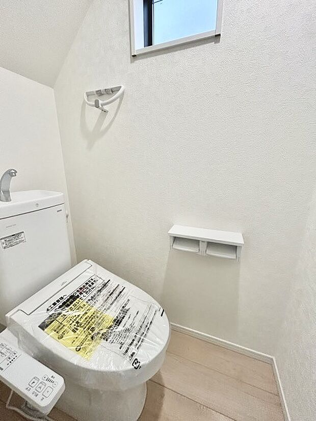 ウォシュレット機能付きのトイレ。換気のしやすい窓付きで、収納もあり実用性も兼ね備えた造り。