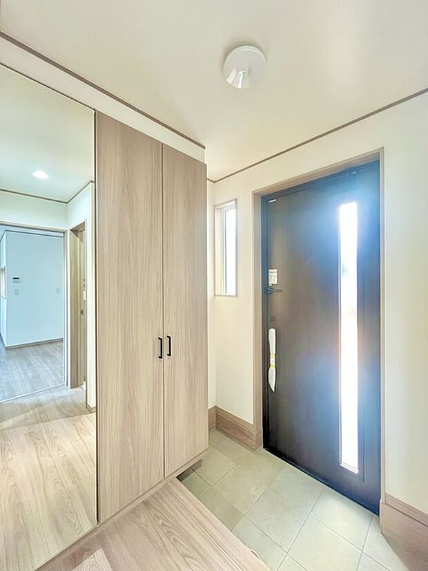 お宅の顔となる明るく開放的な玄関。ご家族皆様様の靴を収納できるスペースと全身鏡があり、お出掛け前に身だしなみチェックもできます。 