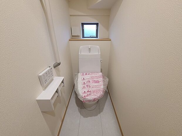 ウォシュレット機能付きのトイレ。換気のしやすい窓付きで、収納もあり実用性も兼ね備えた造り。