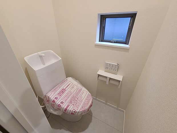 ウォシュレット機能付きのトイレ。換気のしやすい窓付きで、収納もあり実用性も兼ね備えた造り。