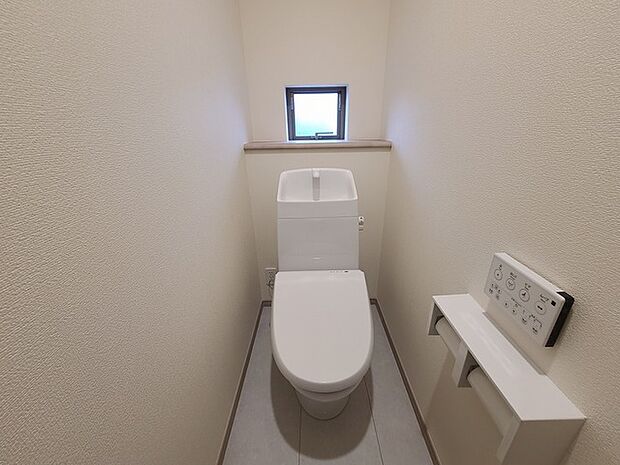 ウォシュレット機能付きのトイレ。換気のしやすい窓付きで、収納もあり実用性も兼ね備えた造り。 