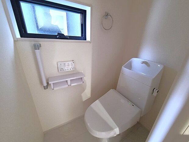 ウォシュレット機能付きのトイレ。換気のしやすい窓付きで、収納もあり実用性も兼ね備えた造り。