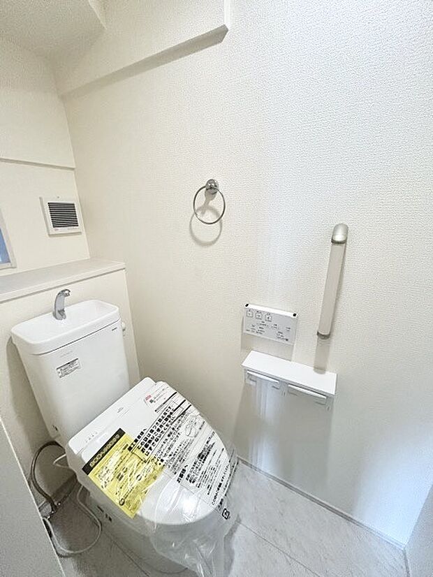 ウォシュレット機能付きのトイレ。収納もあり実用性も兼ね備えた造り。 