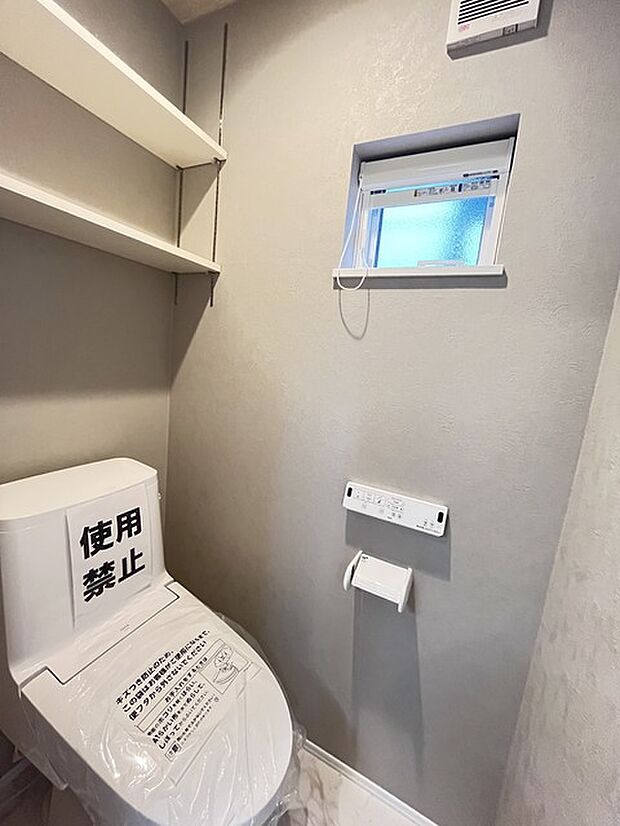 ウォシュレット機能付きのトイレ。換気のしやすい窓付きで、収納もあり実用性も兼ね備えた造り。