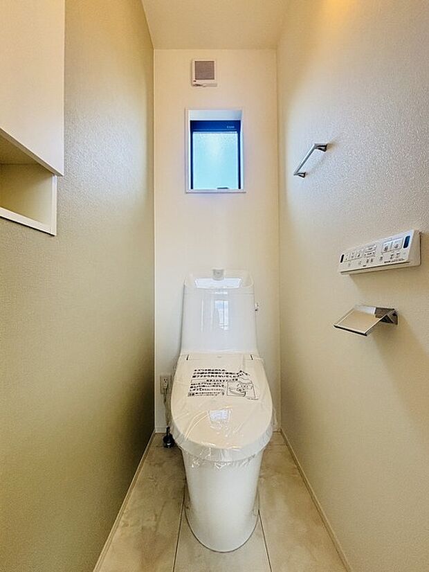 ウォシュレット機能付きのトイレ。換気のしやすい窓付きで、収納もあり実用性も兼ね備えた造り。