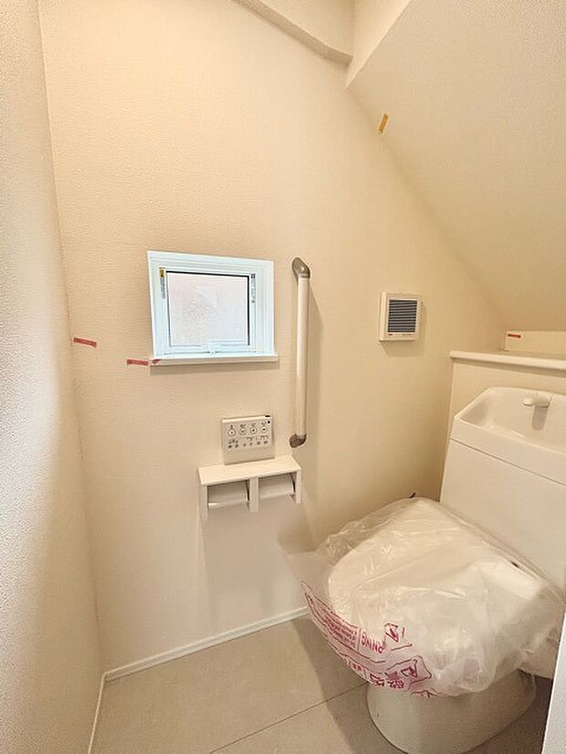 ウォシュレット機能付きのトイレ。換気のしやすい窓付きで、収納もあり実用性も兼ね備えた造り。