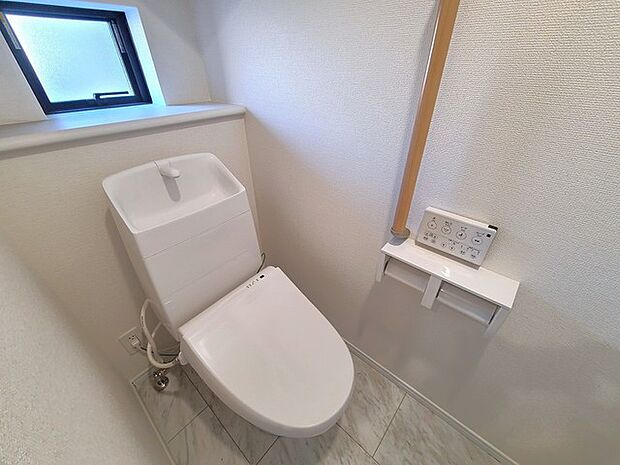 ウォシュレット機能付きのトイレ。換気のしやすい窓付きで、収納もあり実用性も兼ね備えた造り。