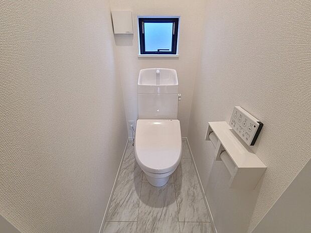 ウォシュレット機能付きのトイレ。換気のしやすい窓付きで、収納もあり実用性も兼ね備えた造り。