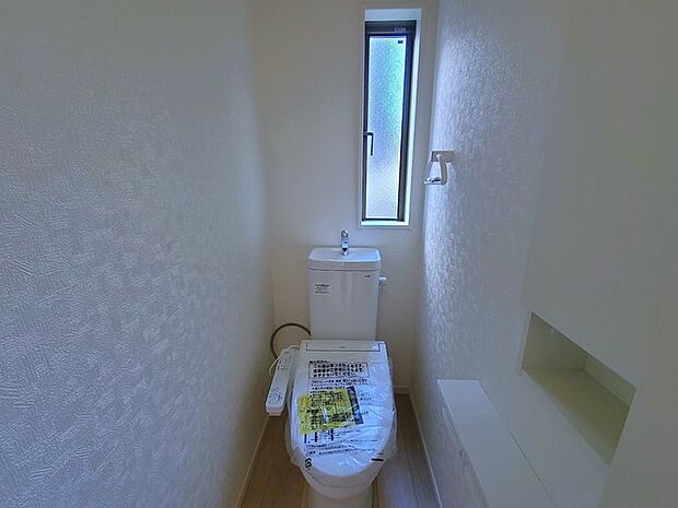 ウォシュレット機能付きのトイレ。換気のしやすい窓付きで、収納もあり実用性も兼ね備えた造り。