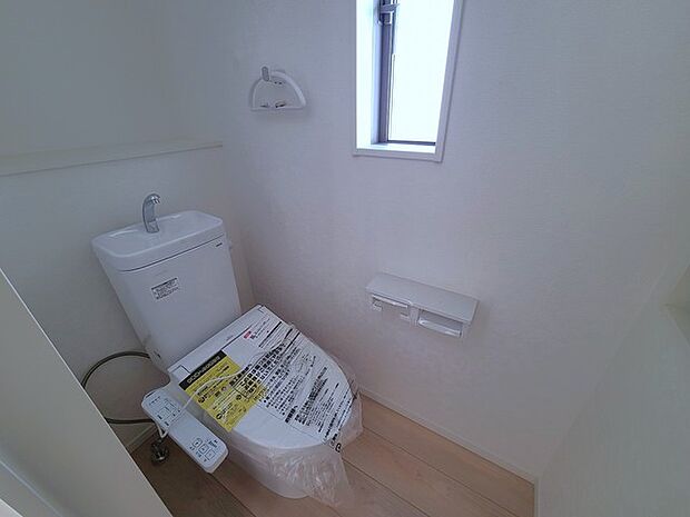 ウォシュレット機能付きのトイレ。換気のしやすい窓付きで、収納もあり実用性も兼ね備えた造り。