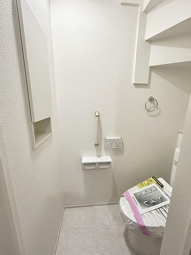 ウォシュレット機能付きのトイレ。収納もあり実用性も兼ね備えた造り。 