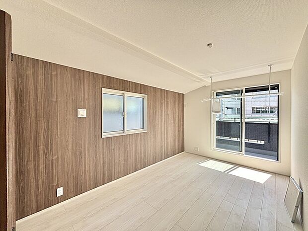 アクセントクロスを使用したオシャレな洋室。窓からそそぐ陽の光が眩しいベッドルームは、朝の目覚めが心地良く迎えられそうです。