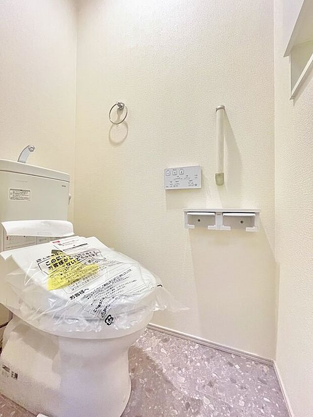 ウォシュレット機能付きのトイレ。収納もあり実用性も兼ね備えた造り。 