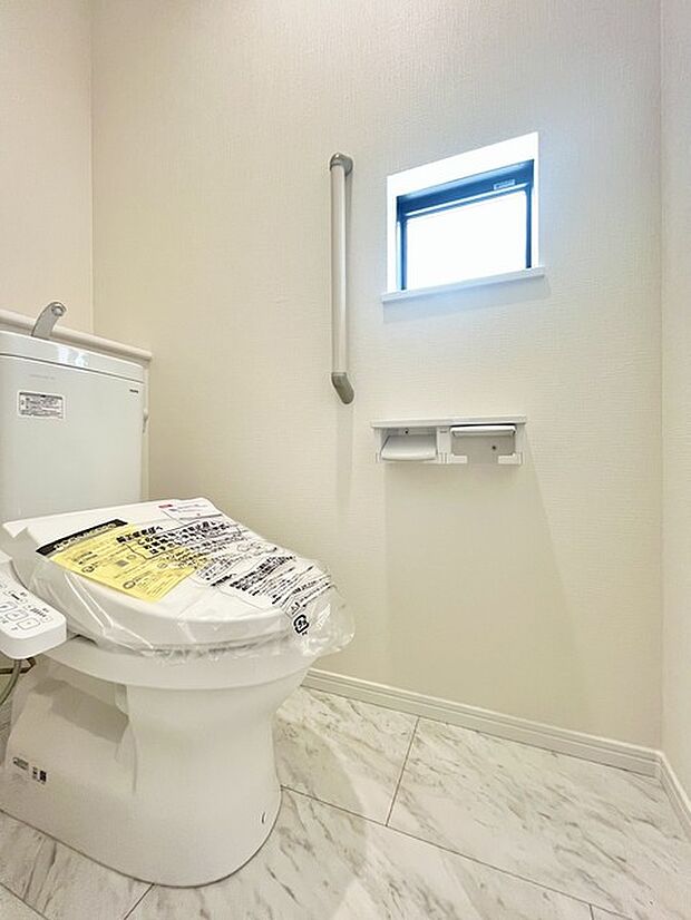 ウォシュレット機能付きのトイレ。換気のしやすい窓付きで、収納もあり実用性も兼ね備えた造り。 
