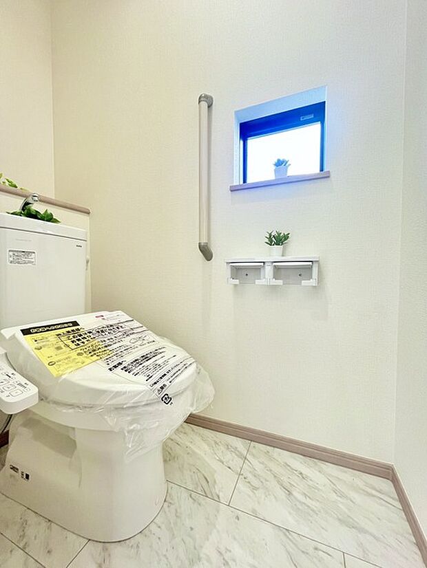 ウォシュレット機能付きのトイレ。換気のしやすい窓付きで、収納もあり実用性も兼ね備えた造り。