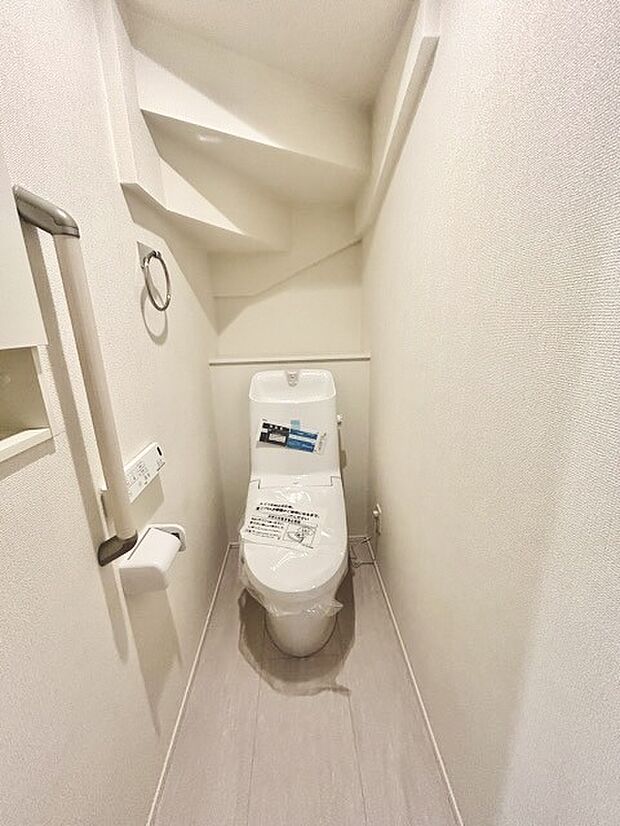 ウォシュレット機能付きのトイレ。収納もあり実用性も兼ね備えた造り。
