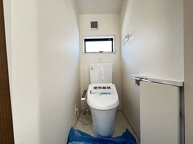 ウォシュレット機能付きのトイレ。収納もあり実用性も兼ね備えた造り。 