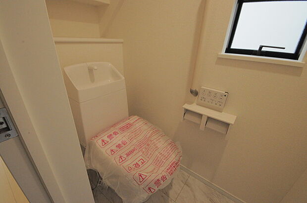 ウォシュレット機能付きのトイレ。換気のしやすい窓付きで、収納もあり実用性も兼ね備えた造り。