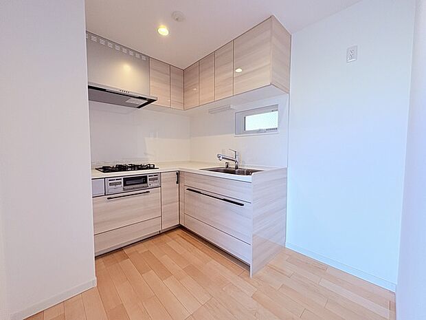 壁付のキッチンは上部に収納が作りやすいのがメリット。空間を有効活用したすっきりとしたデザイン。