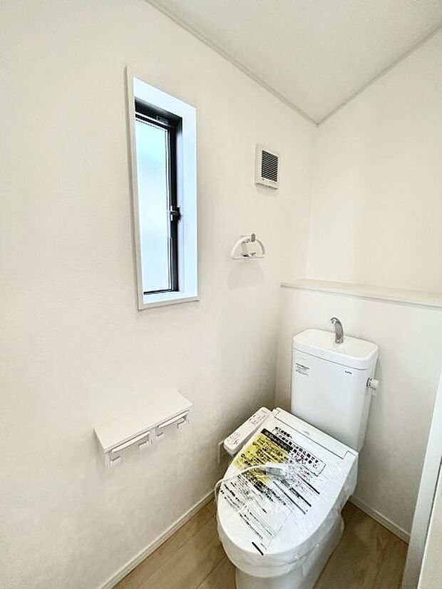 ウォシュレット機能付きのトイレ。換気のしやすい窓付きで、収納もあり実用性も兼ね備えた造り。