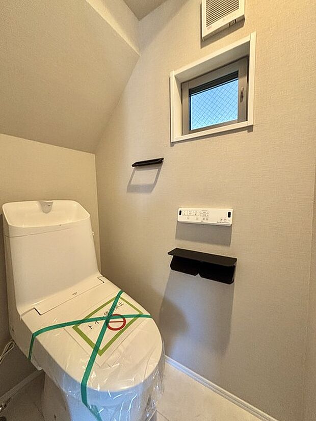 ウォシュレット機能付きのトイレ。換気のしやすい窓付きで、収納もあり実用性も兼ね備えた造り。