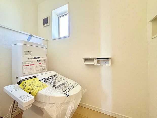 ウォシュレット機能付きのトイレ。換気のしやすい窓付きで、収納もあり実用性も兼ね備えた造り。