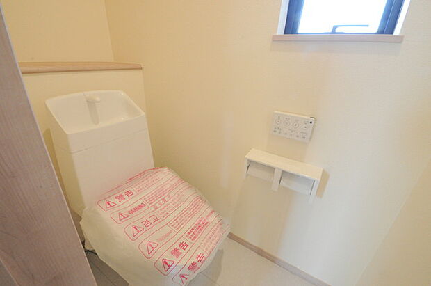 ウォシュレット機能付きのトイレ。換気のしやすい窓付きで、収納もあり実用性も兼ね備えた造り。 