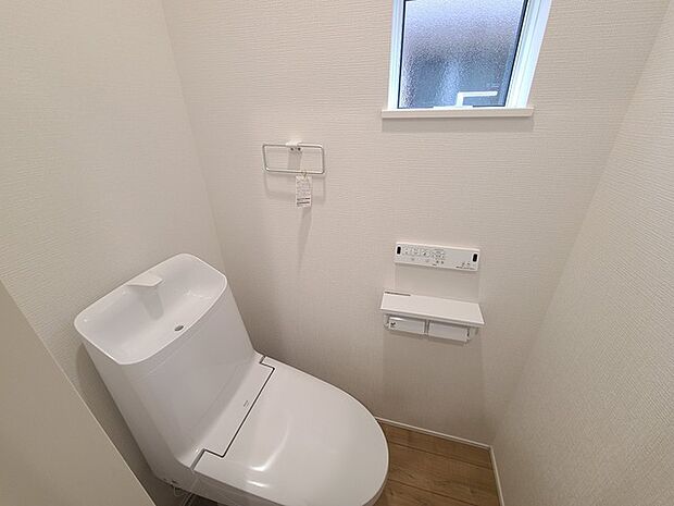 ウォシュレット機能付きのトイレ。換気のしやすい窓付きで、収納もあり実用性も兼ね備えた造り。