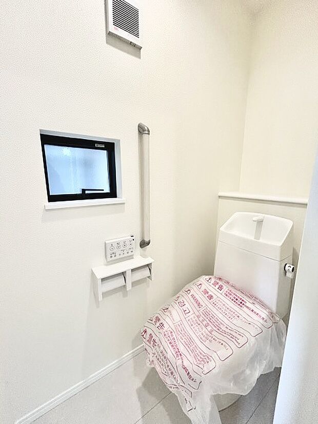 ウォシュレット機能付きのトイレ。換気のしやすい窓付きで、収納もあり実用性も兼ね備えた造り。