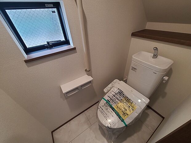 ウォシュレット機能付きのトイレ。換気のしやすい窓付きで、収納もあり実用性も兼ね備えた造り。 