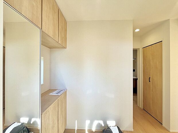 お宅の顔となる明るく開放的な玄関。ご家族皆様様の靴を収納できるスペースと全身鏡があり、お出掛け前に身だしなみチェックもできます。 